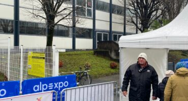 Agent de sécurité surveillant l'entrée d'un bâtiment d'entreprise pour assurer la protection des lieux et des collaborateurs.