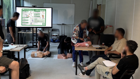 Formation pratique aux gestes de premiers secours avec utilisation de mannequins pour adultes et nourrissons dans une salle de formation.